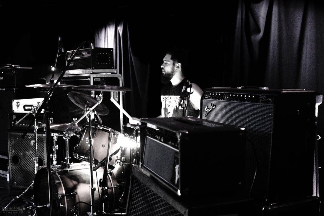 a man is playing drums in a black and white photo .