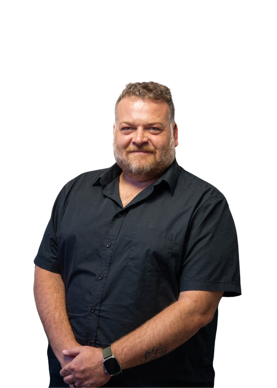 Smiling person in a black shirt standing against a white background, hands clasped in front.