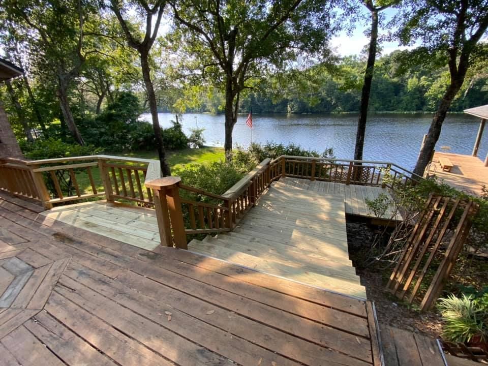 Two people review architectural blueprints and a laptop on a table with a yellow hard hat and calculators.