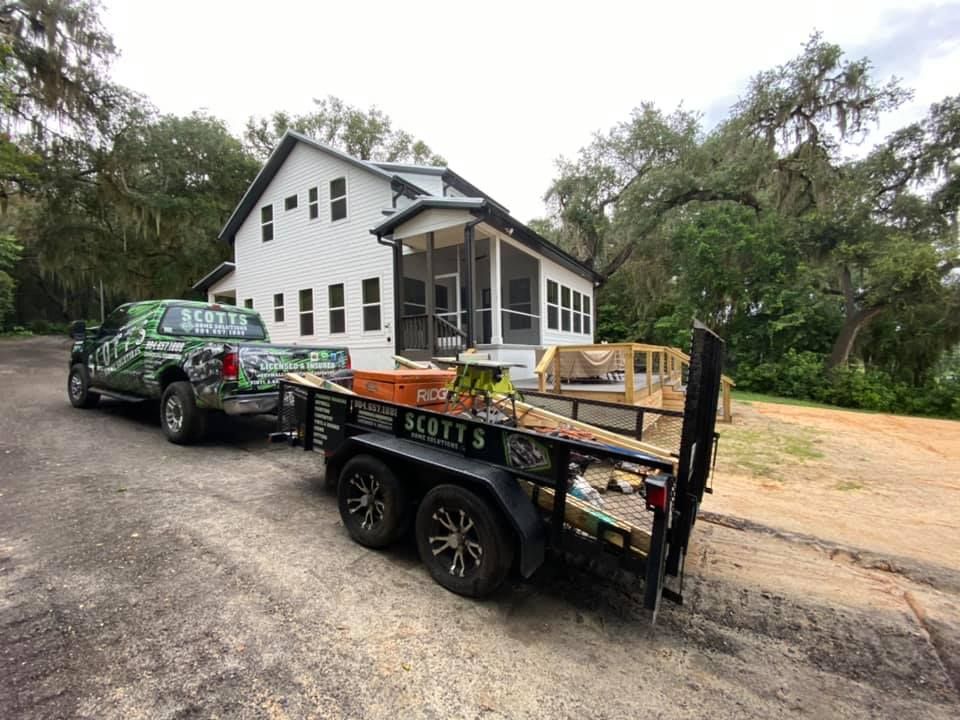 A person measuring the width of a white kitchen cabinet with a yellow tape measure.