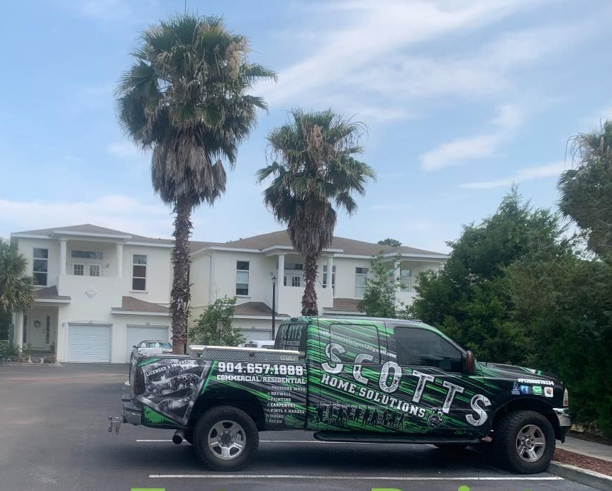 A pneumatic flooring nailer is positioned to install a hardwood floor plank in a room.