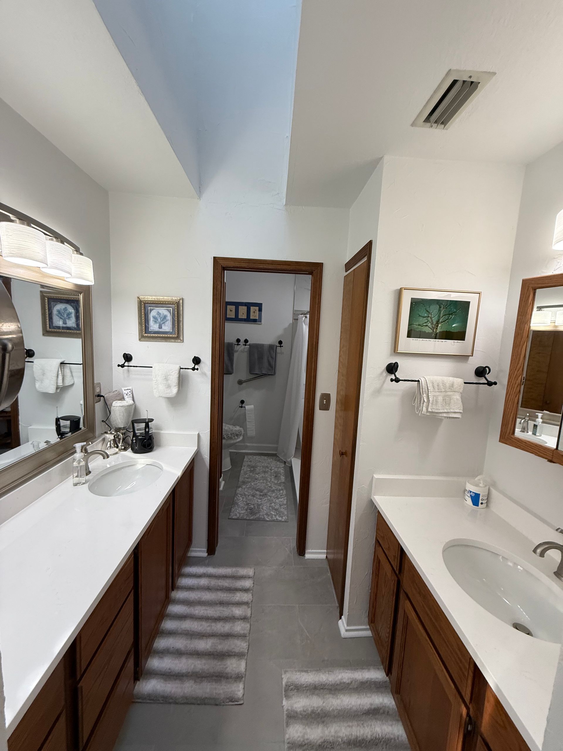 Hands installing a modern chrome shower control valve onto a tiled wall.