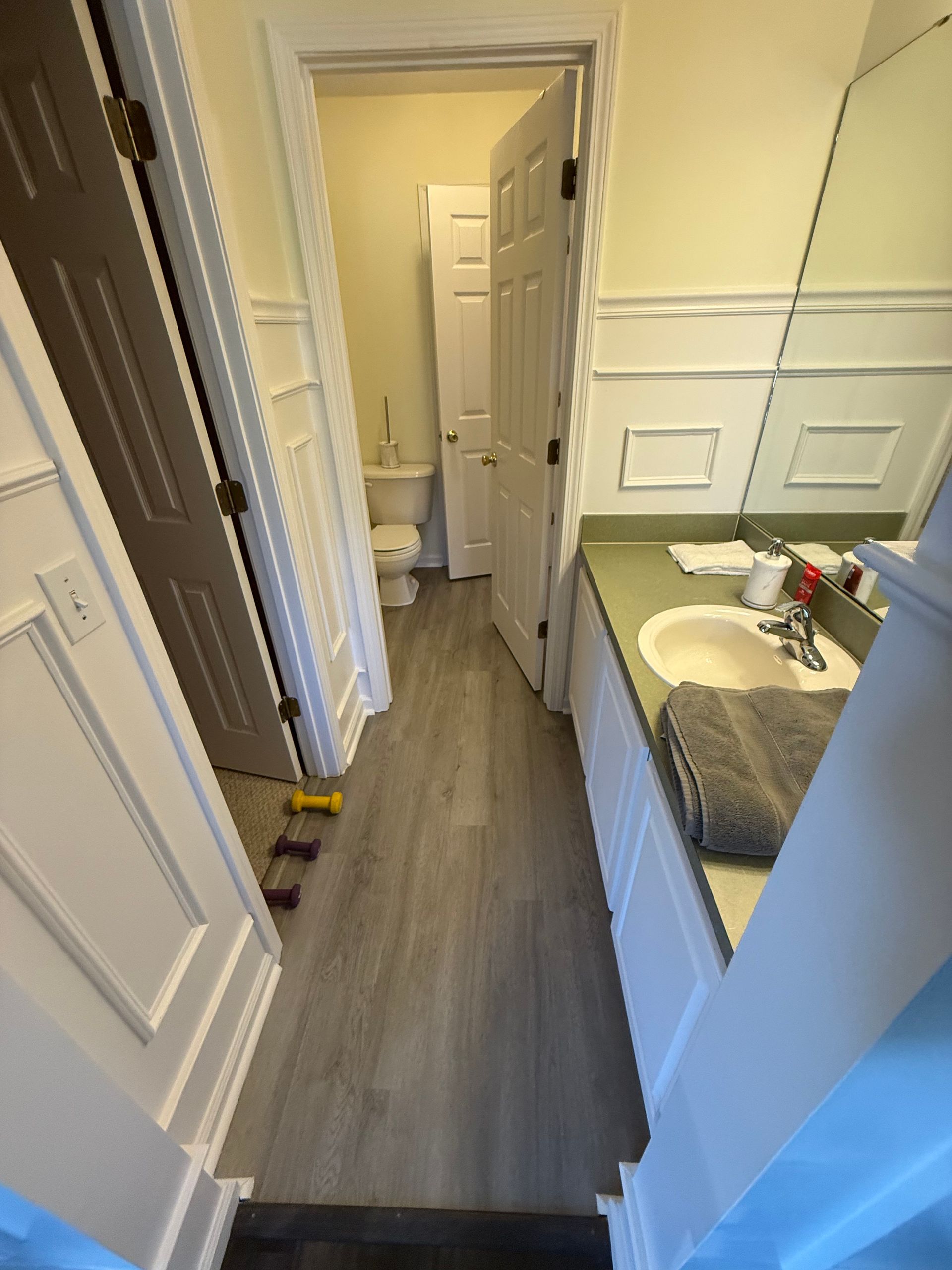 A professional installing a glass shower door in a modern bathroom.