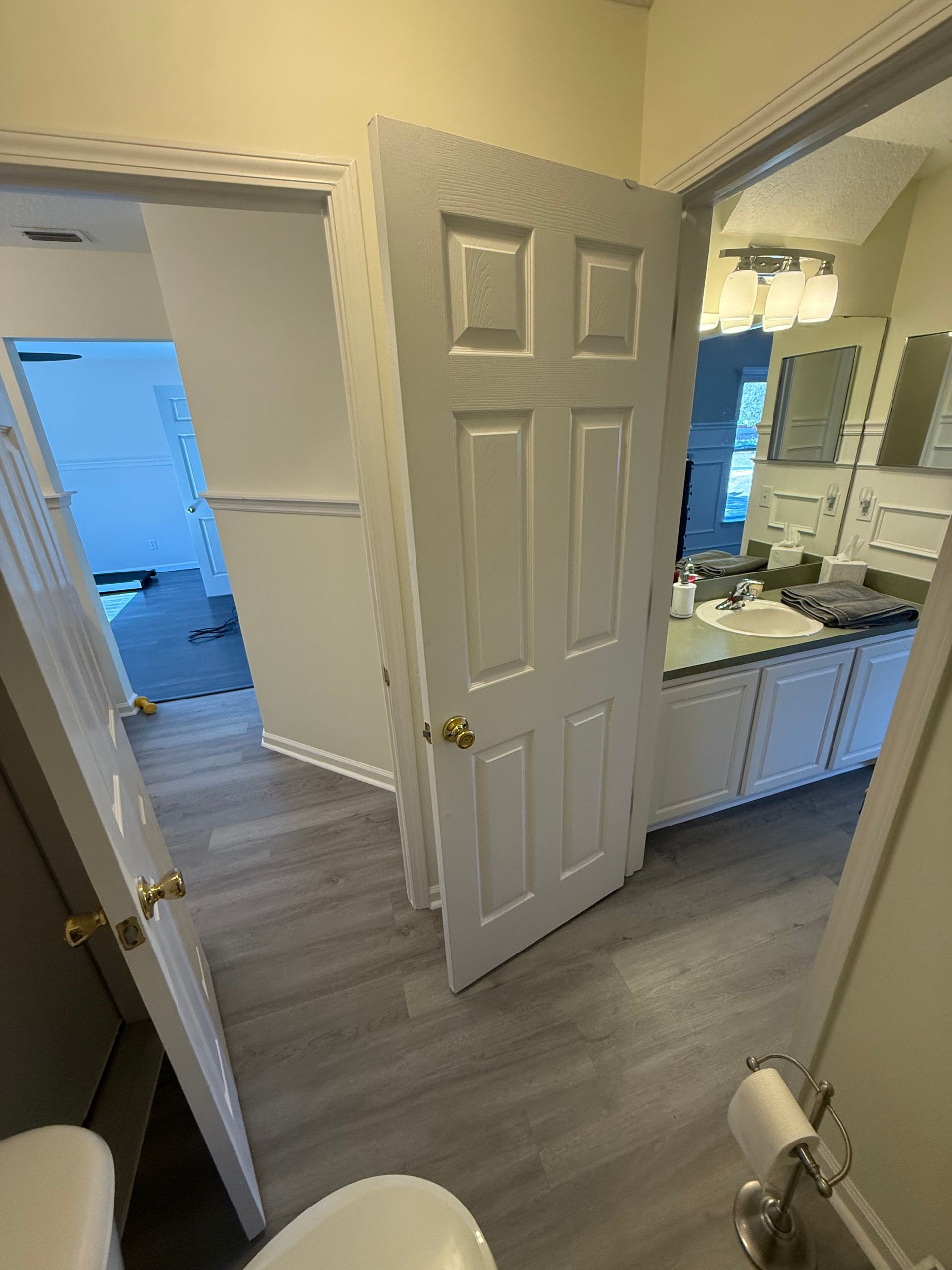 A bathroom with a tiled walk-in shower, a soaking tub, and a wooden vanity cabinet next to a window with frosted glass.
