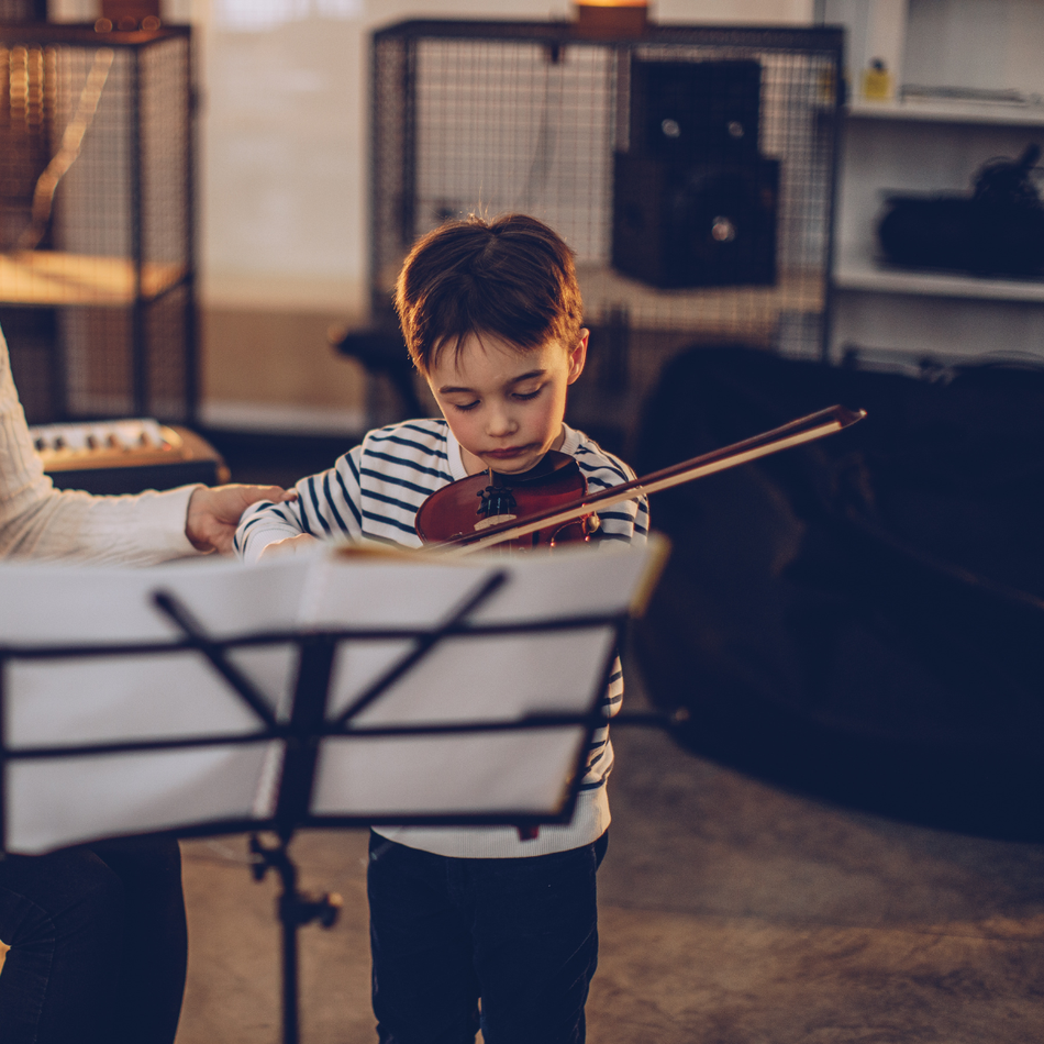 A man is working on a piano with a screwdriver.
