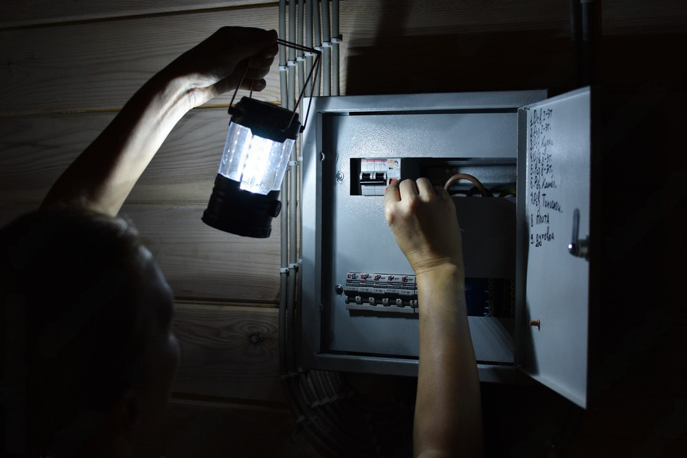 a person is working on an electrical box with a flashlight