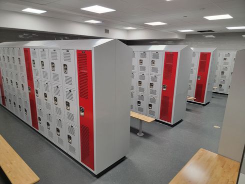 Locker room with white and red lockers in a bright indoor space