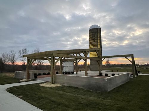 Rural farm shelter and silo at dusk under a cloudy sky