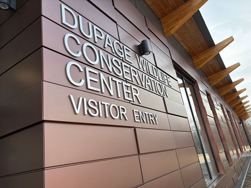 Dupage County Conservation Center visitor entrance sign on a modern building wall