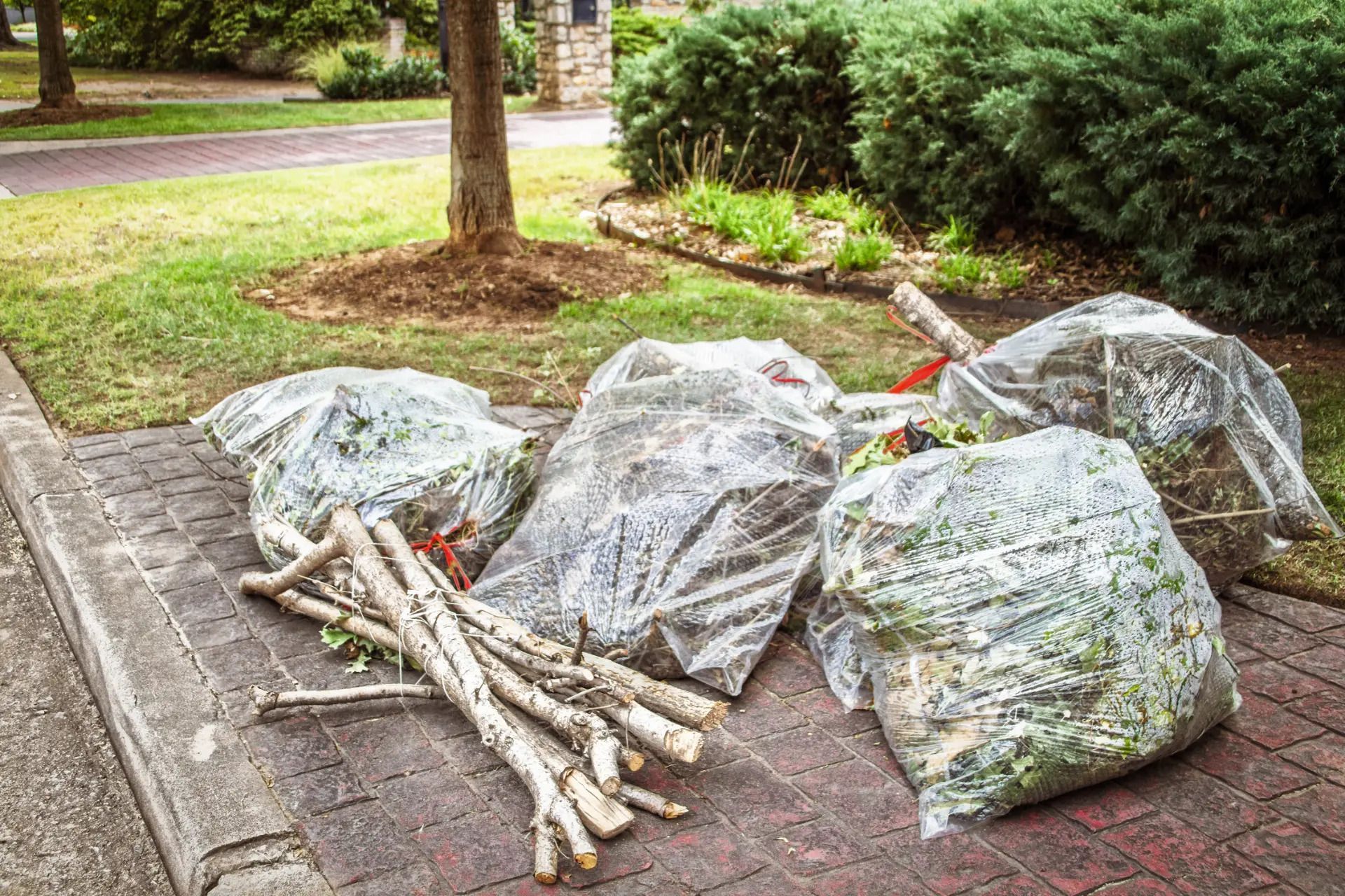 A bunch of bags of wood are sitting on the sidewalk