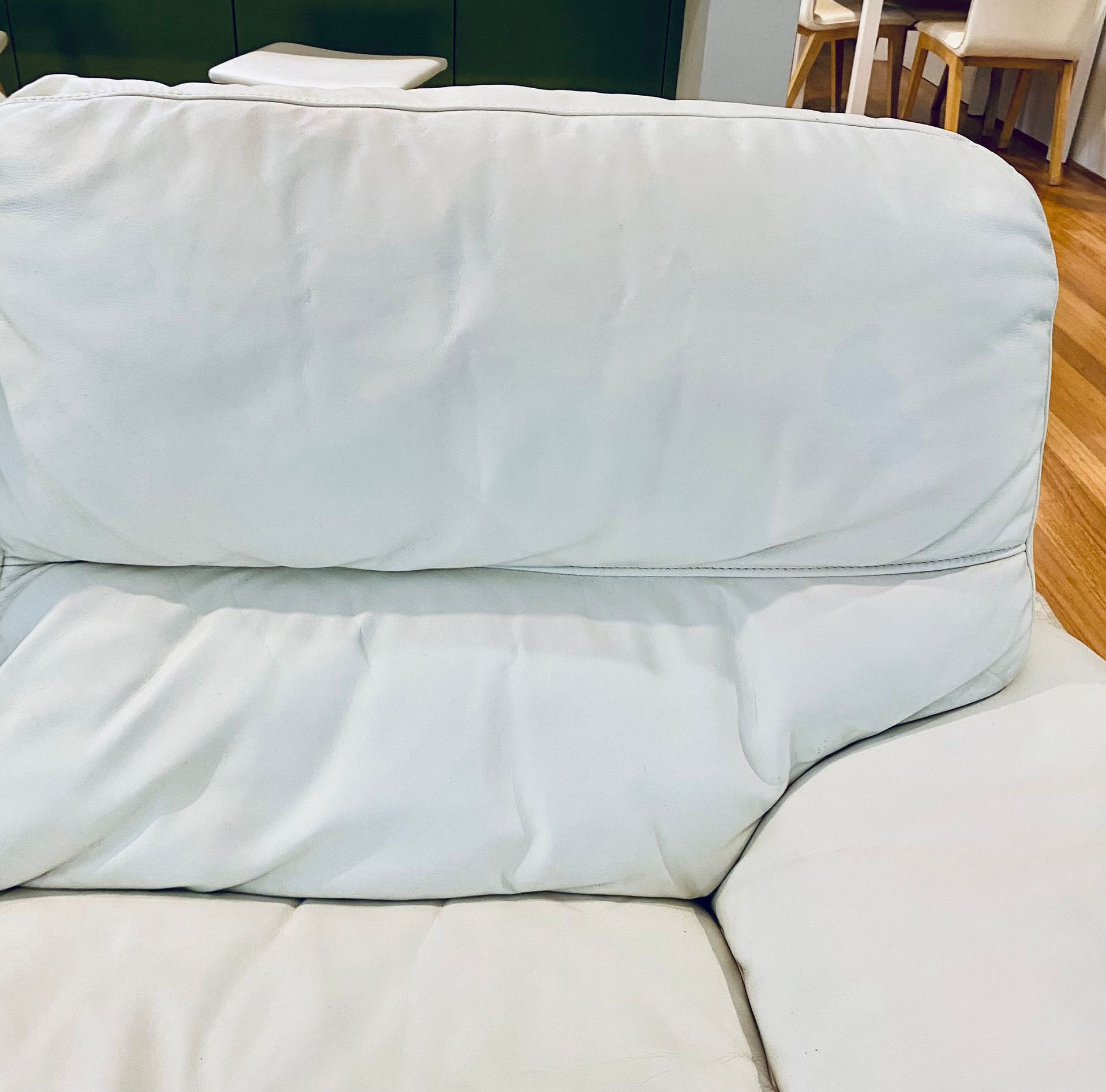 A white leather couch is sitting on a wooden floor — Furniture & Auto Pride In Port Macquarie, NSW