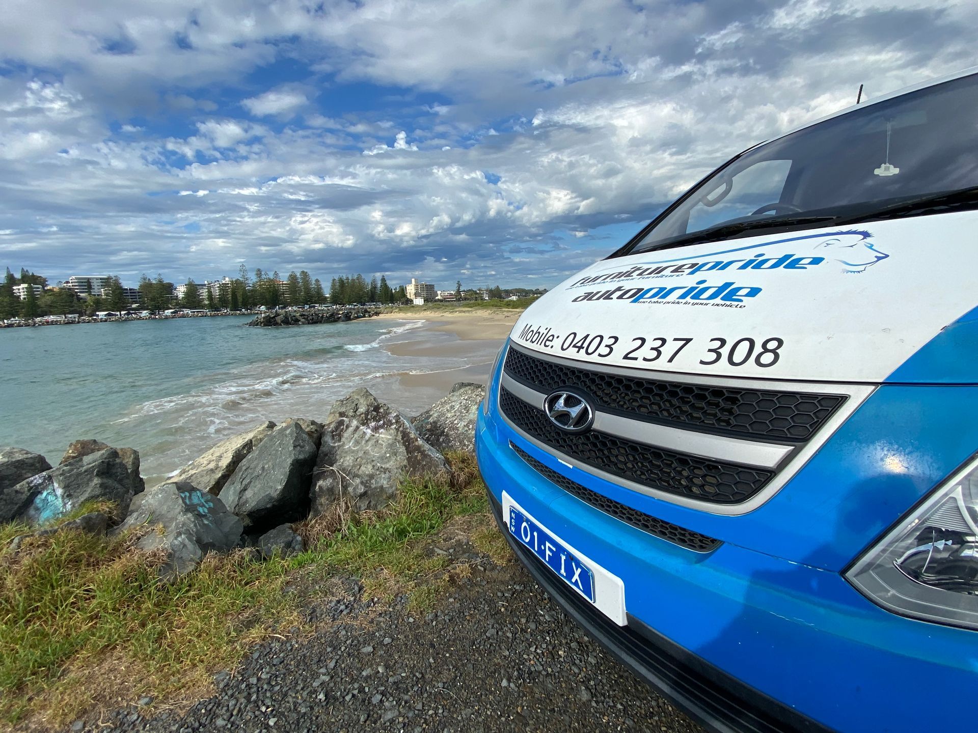 A Living Room With a Brown Sectional Couch and Pictures on the Wall — Furniture & Auto Pride in Port Macquarie, NSW