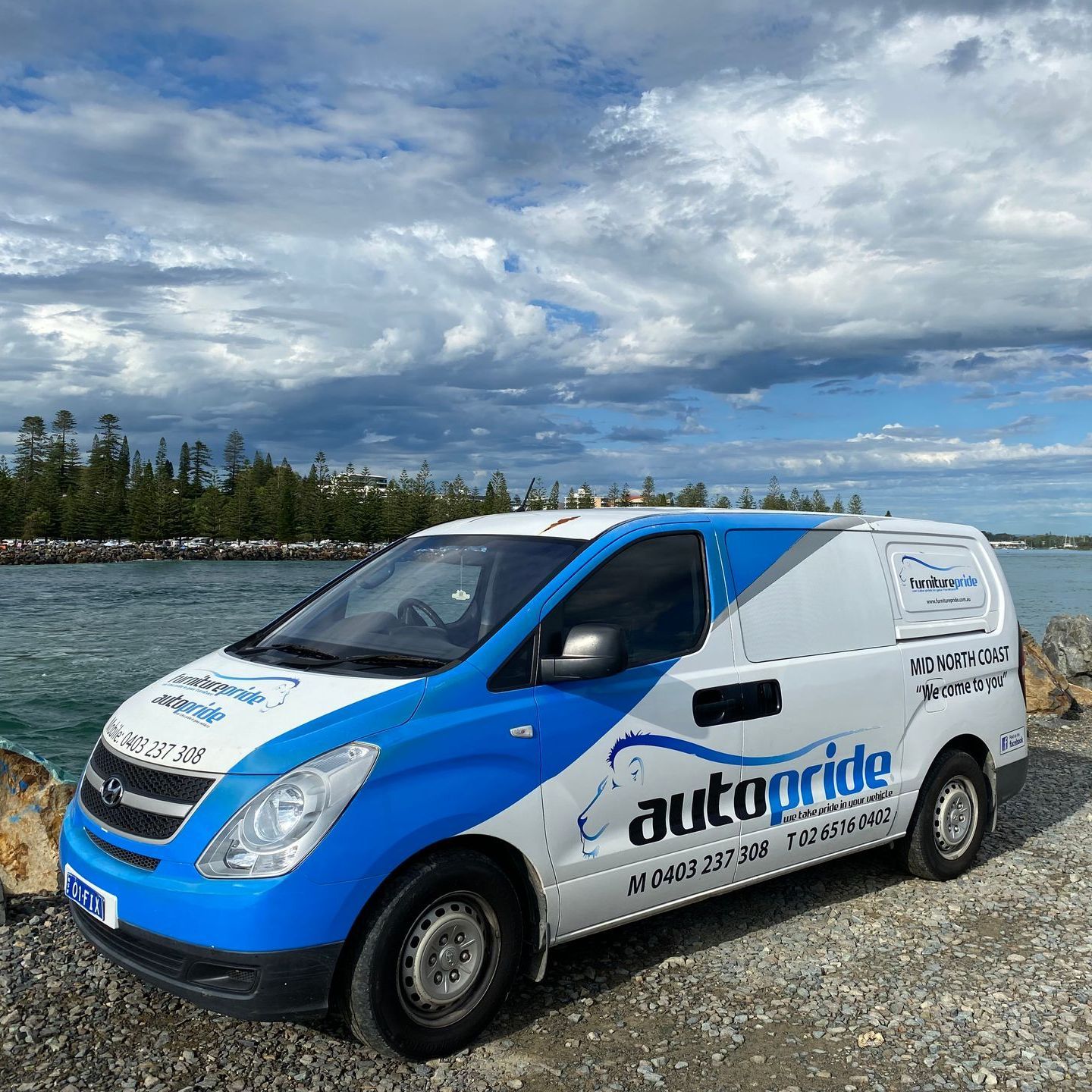 A sign written van in front of a lake — Furniture & Auto Pride in Port Macquarie, NSW
