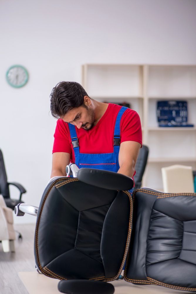 A Man is Fixing an Office Chair in an Office — Furniture & Auto Pride in Laurieton, NSW