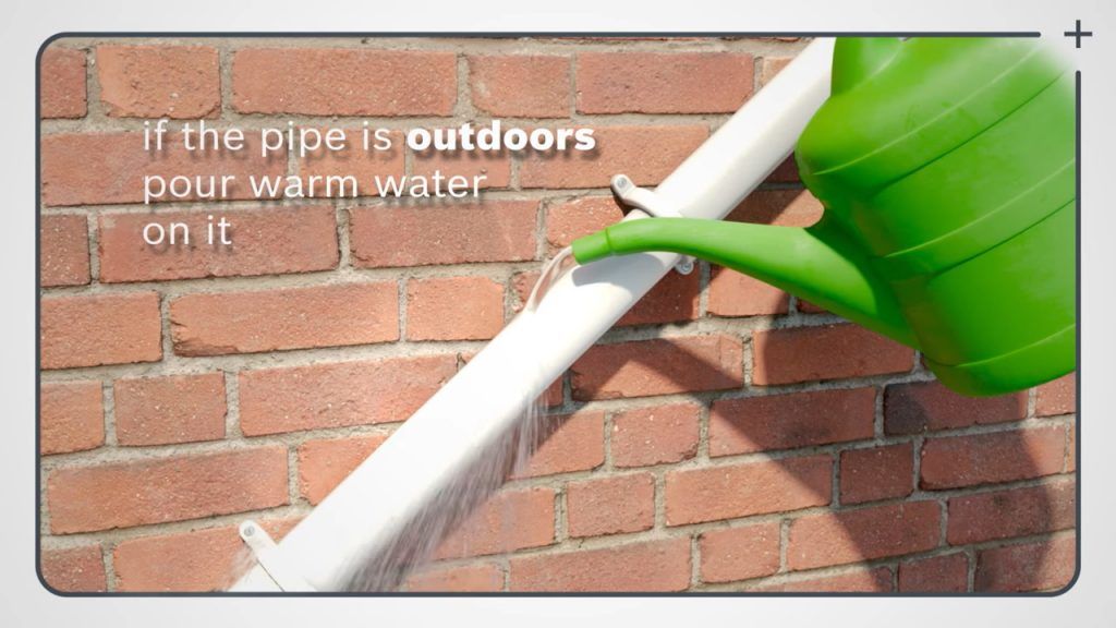 Frozen boiler condensate pipe with visible ice buildup on an external plastic drain pipe.