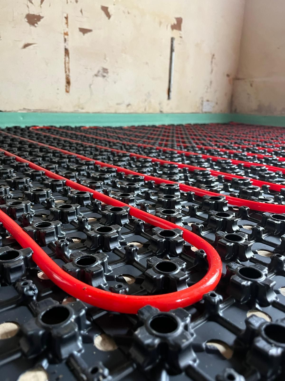 Engineer servicing underfloor heating manifold and valves