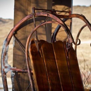 A wooden chair with a saw attached to it