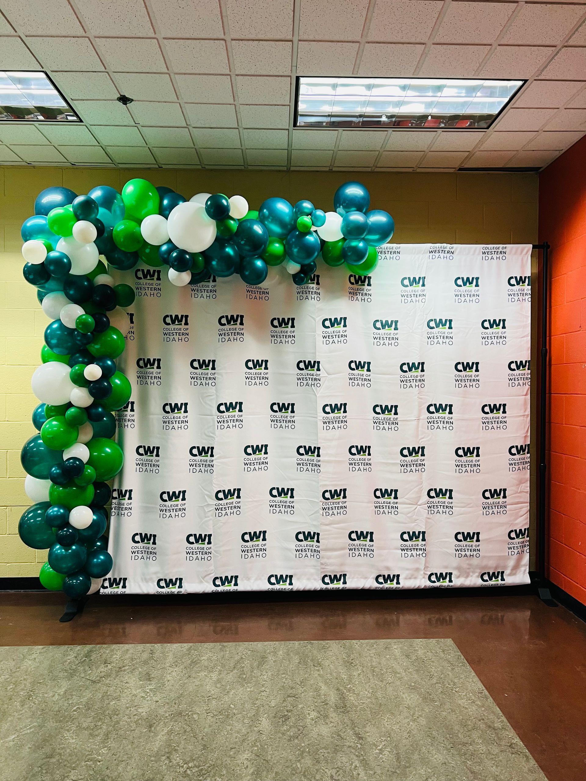A wall with green and white balloons on it