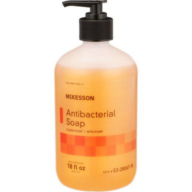 Antibacterial soap bottle with a black pump, orange liquid, and