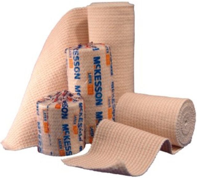 Several beige McKesson latex bandages in rolls and unrolled.