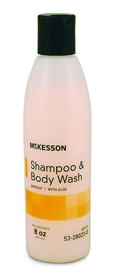 A peach-colored bottle of McKesson shampoo and body wash with a black cap.
