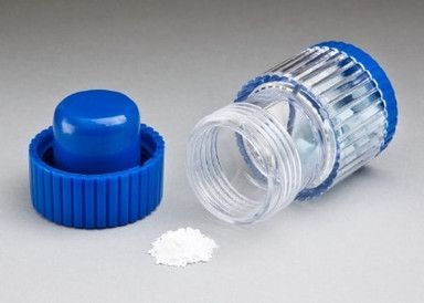 Blue pill cutter with cap and crushed pills.