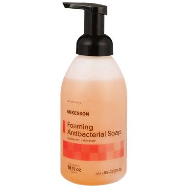 Foaming antibacterial soap dispenser, peach colored liquid with black pump. McKesson brand.