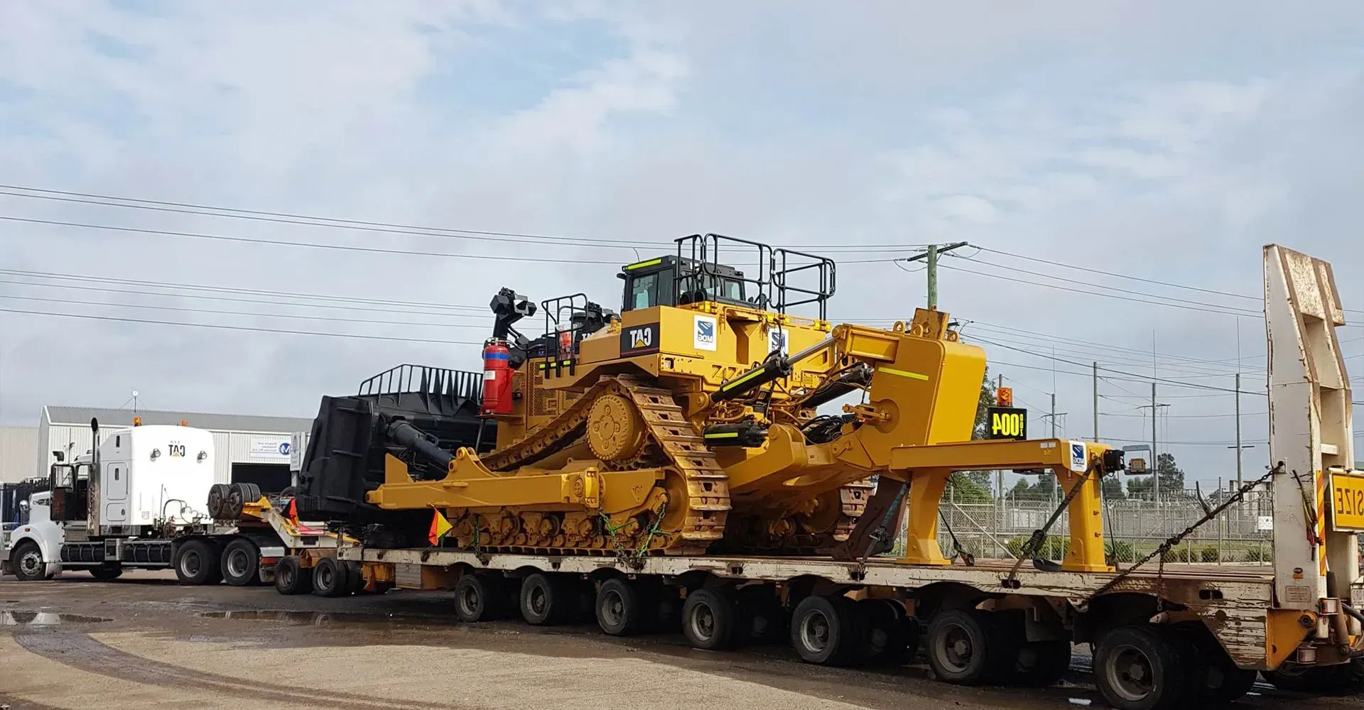 A Large Yellow Bulldozer is Being Transported on a Trailer — Rutherford, NSW — Goldsprings Heavy Haulage