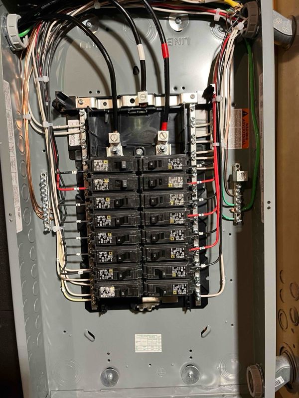 A close up of a electrical panel with a lot of wires coming out of it.