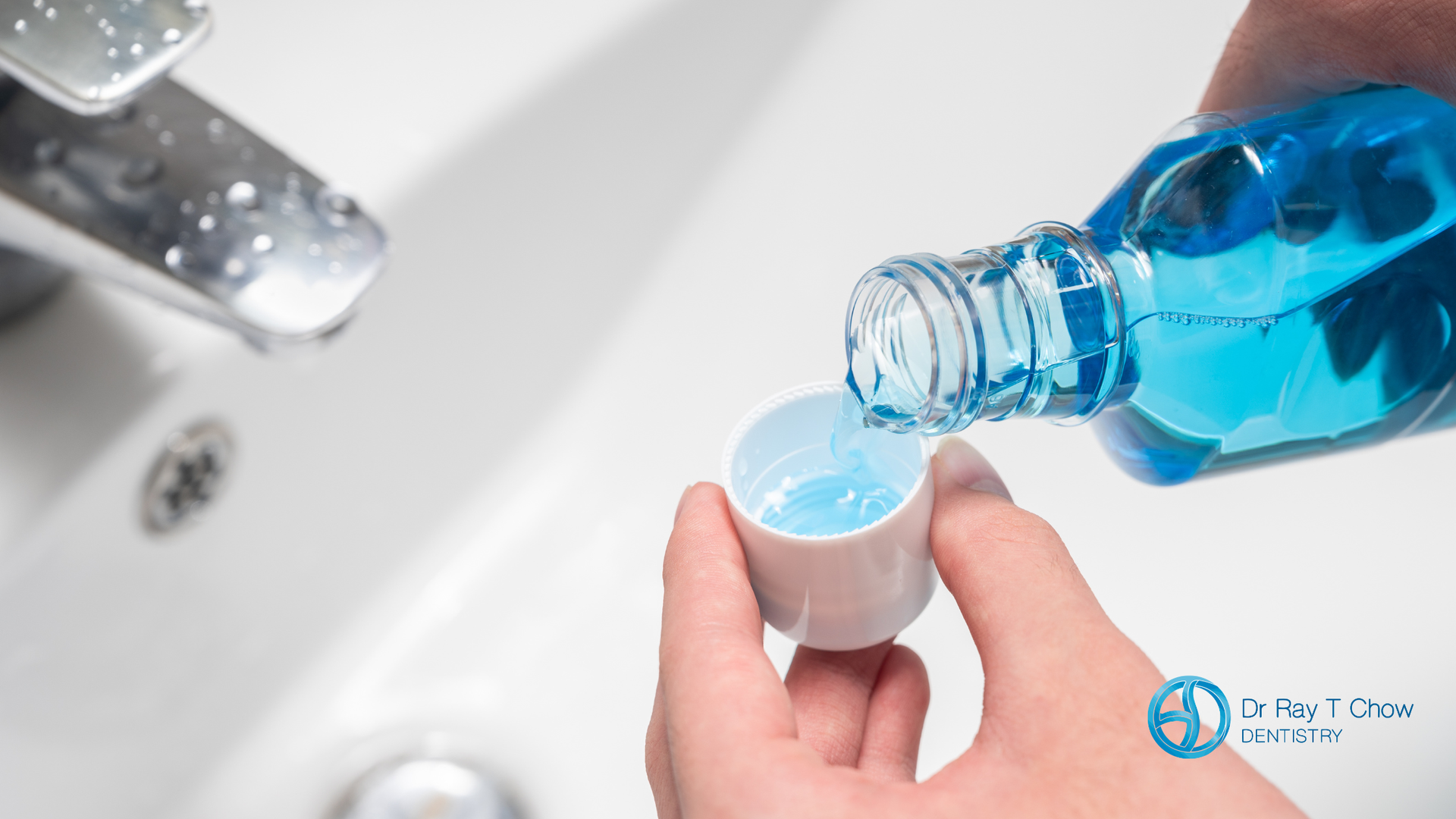 Blue mouthwash being poured into a small cup next to a white sink.