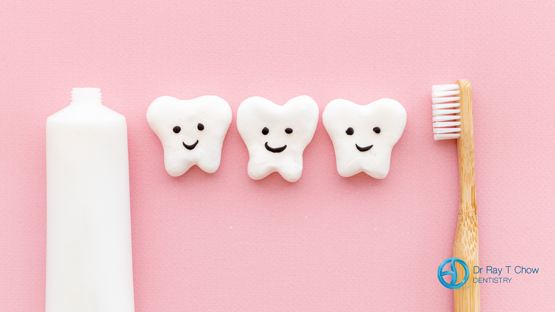 Toothpaste, happy tooth shapes, and toothbrush on a pink background.