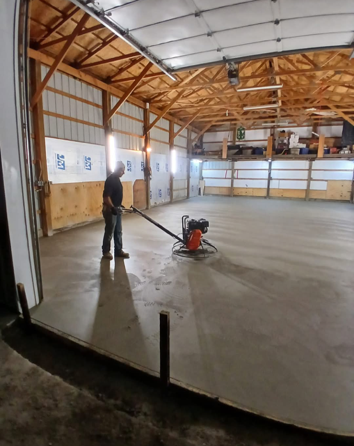 A modern, light-beige two-story residential house with a built-in garage and a covered entrance on a sunny day.