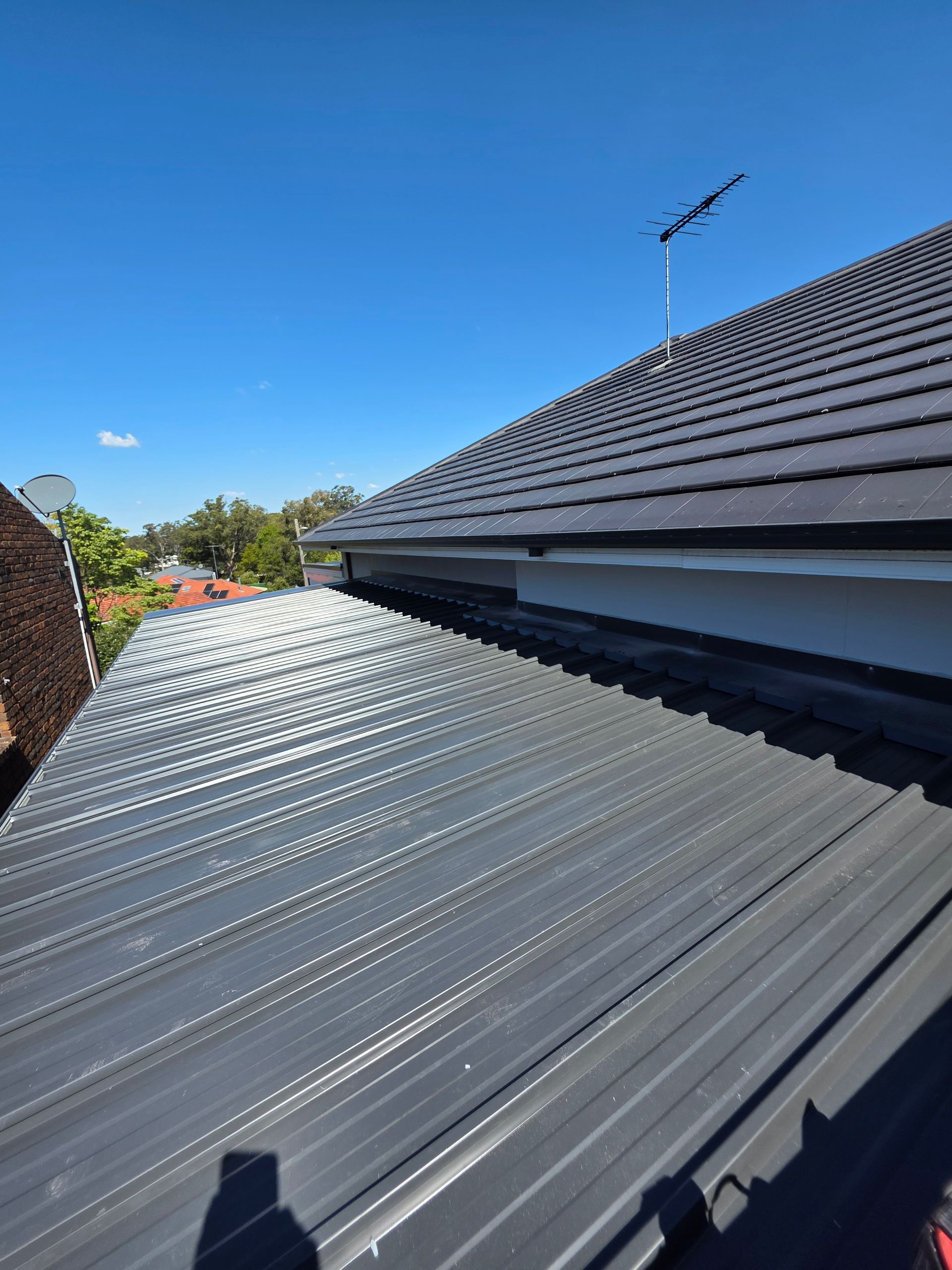 A Metal Roof Reflecting Sunlight — McLuckie Metal Roofing In Liverpool, NSW