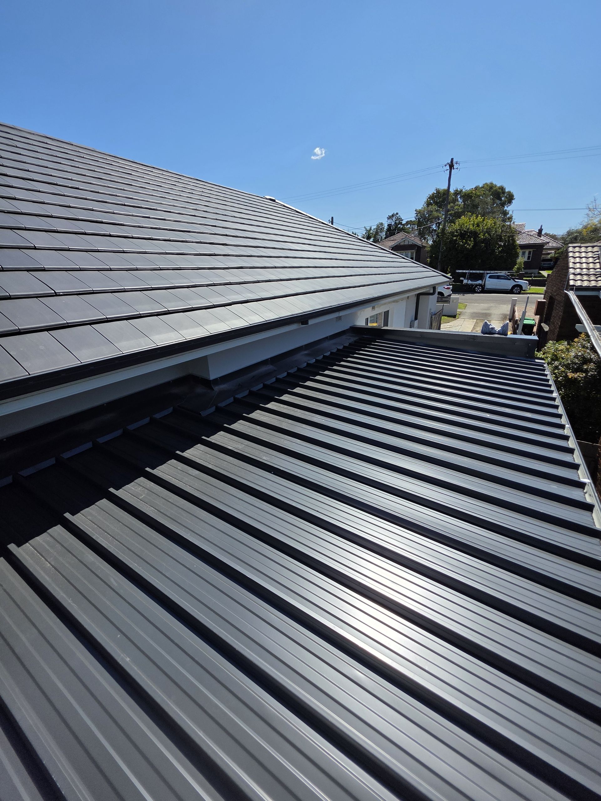 Gray corrugated metal roof under a blue sky — McLuckie Metal Roofing In St George, NSW