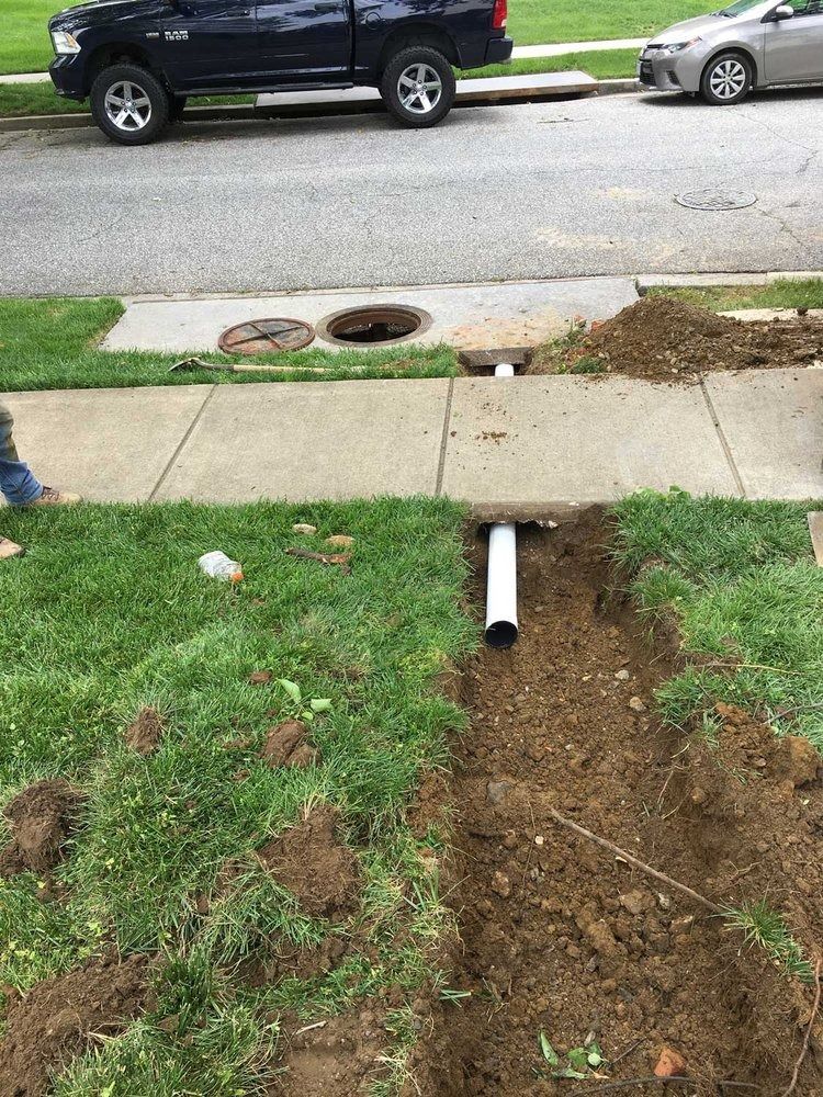 A black truck is parked on the side of the road next to a sidewalk.