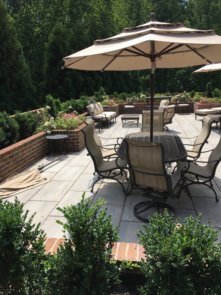 A patio with a table and chairs under an umbrella