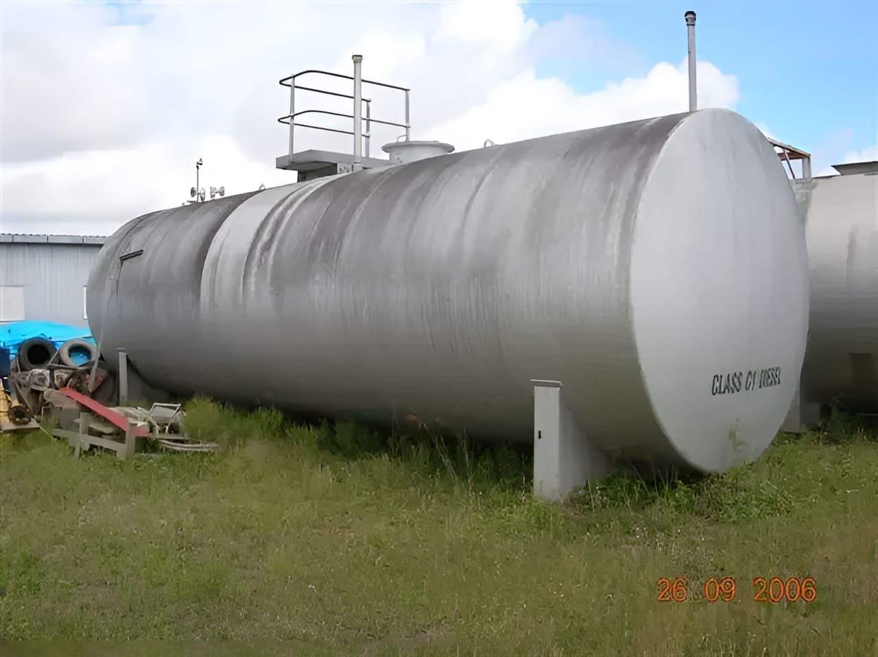 A Large Stainless Steel Tank Is Sitting In A Grassy Field — Tyrepower Innisfail In Goondi Bend, QLD