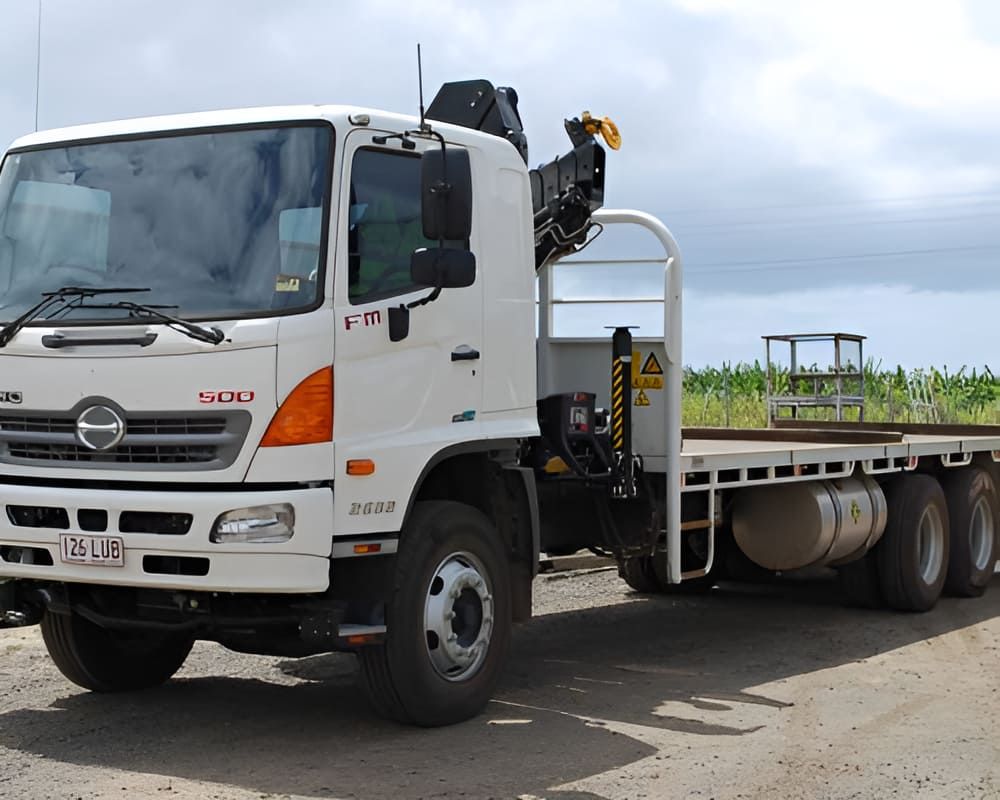 A White Truck With A Flatbed Is Parked On A Dirt Road — Tyrepower Innisfail In Goondi Bend, QLD