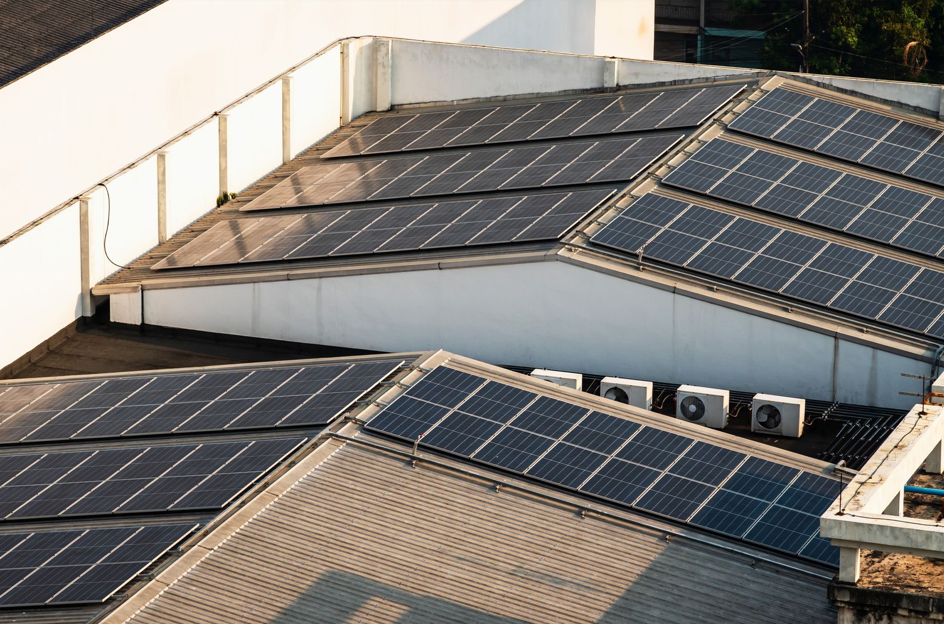 There are many solar panels on the roof of a building.