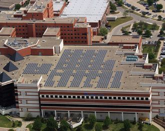 An aerial view of a large building with solar panels on the roof