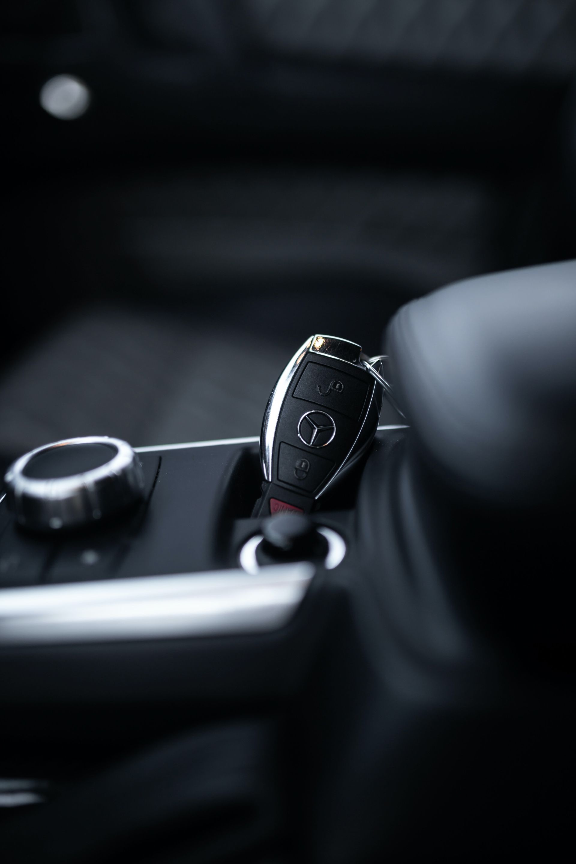 A car key is sitting in the center console of a car.