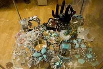 A Glass Table Topped With A Variety Of Jewelry And A Hand — Ballistic Chix In Forster, NSW
