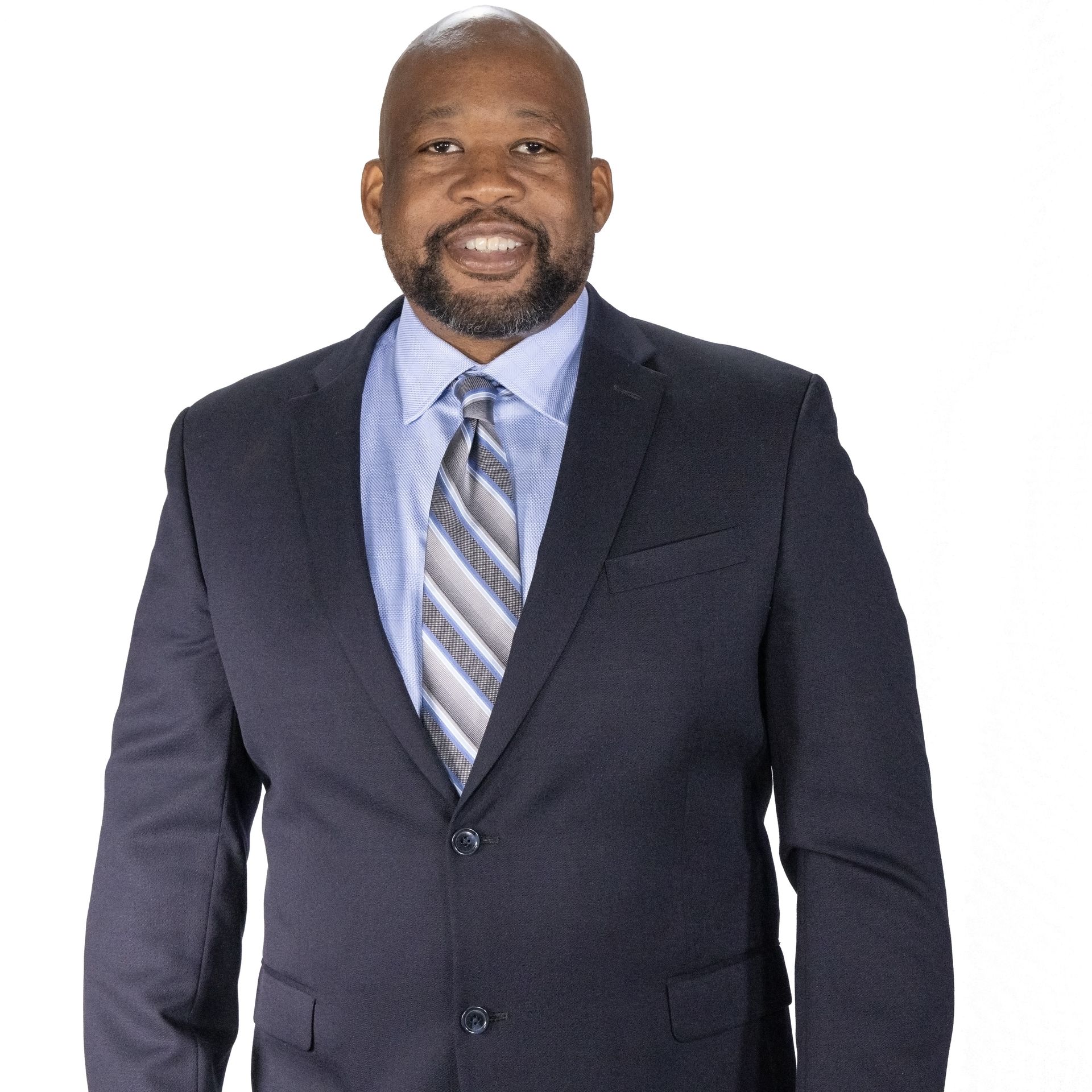 Man in a suit smiles, wearing a tie with stripes, against a white background.