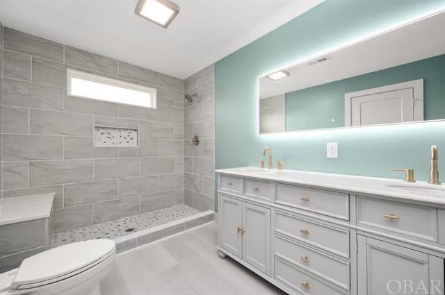 Modern bathroom with gray tile shower, white vanity, and teal walls.
