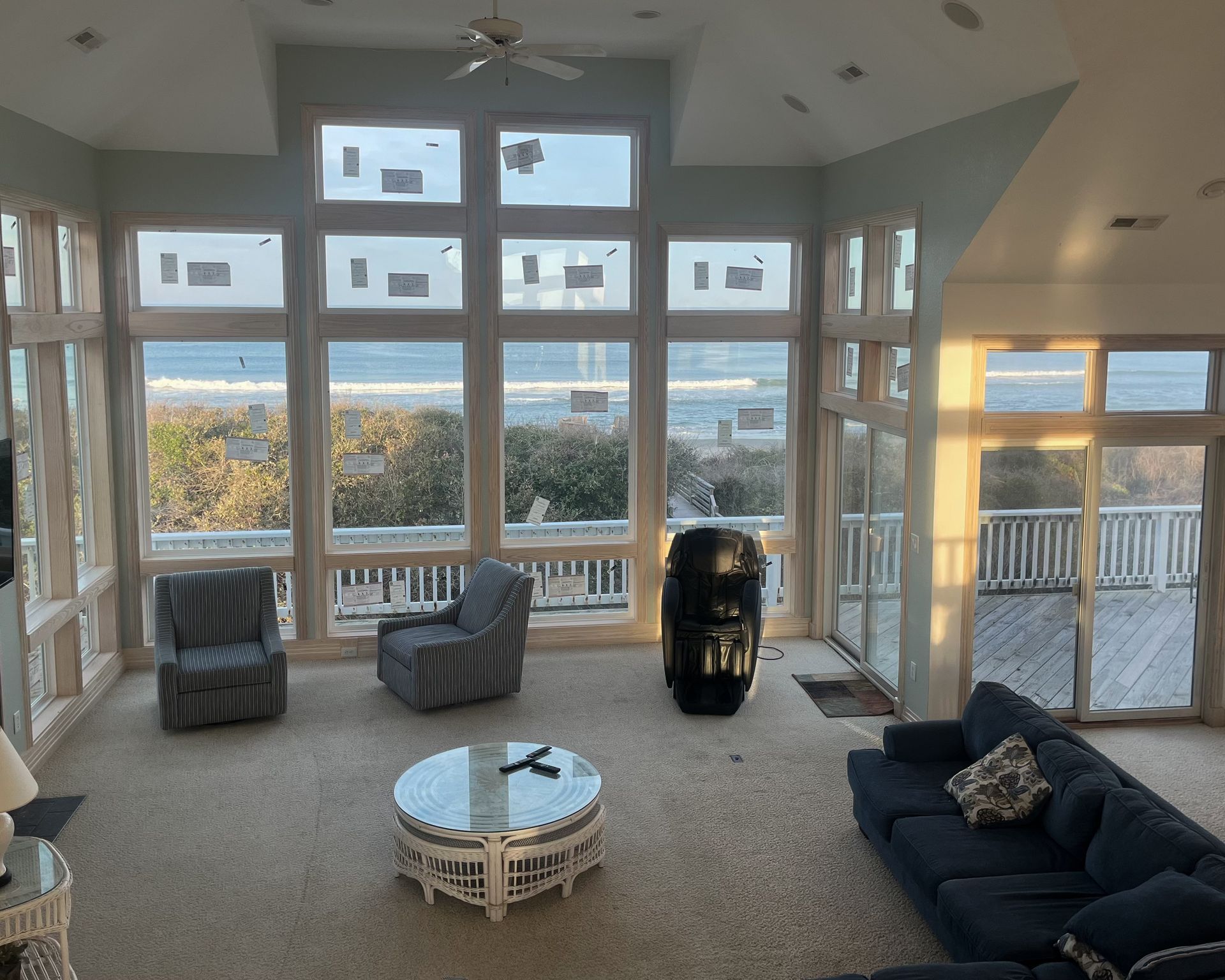 Living room with ocean view, large windows, furniture, and a rug.