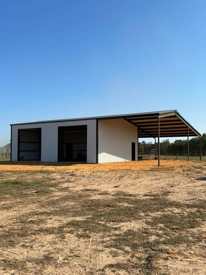 White metal barn with a carport on a sunny, clear day.