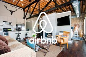 a living room with a couch , chairs , television and a logo for airbnb .