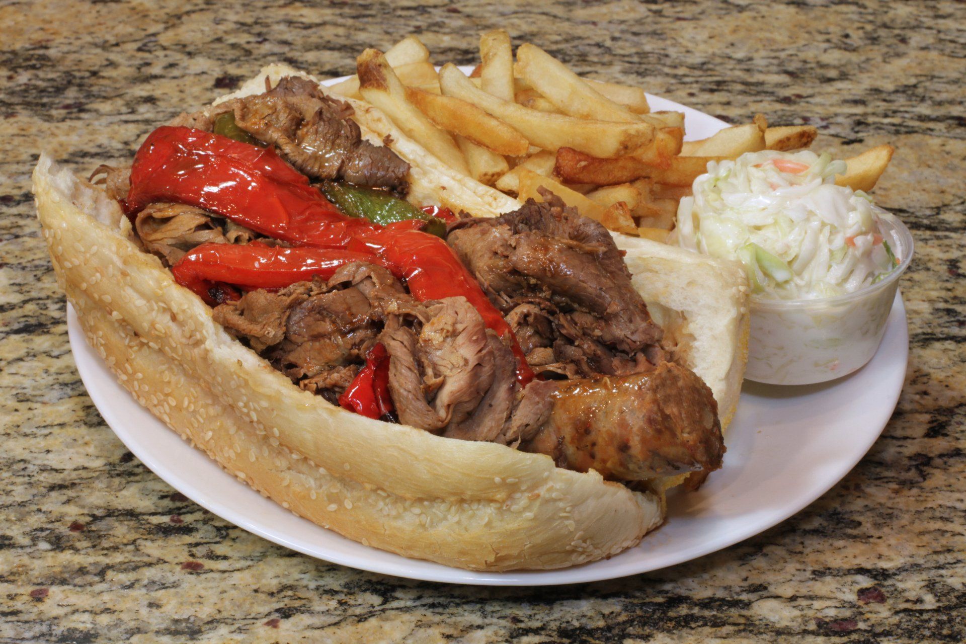 A sandwich with french fries and coleslaw on a plate.