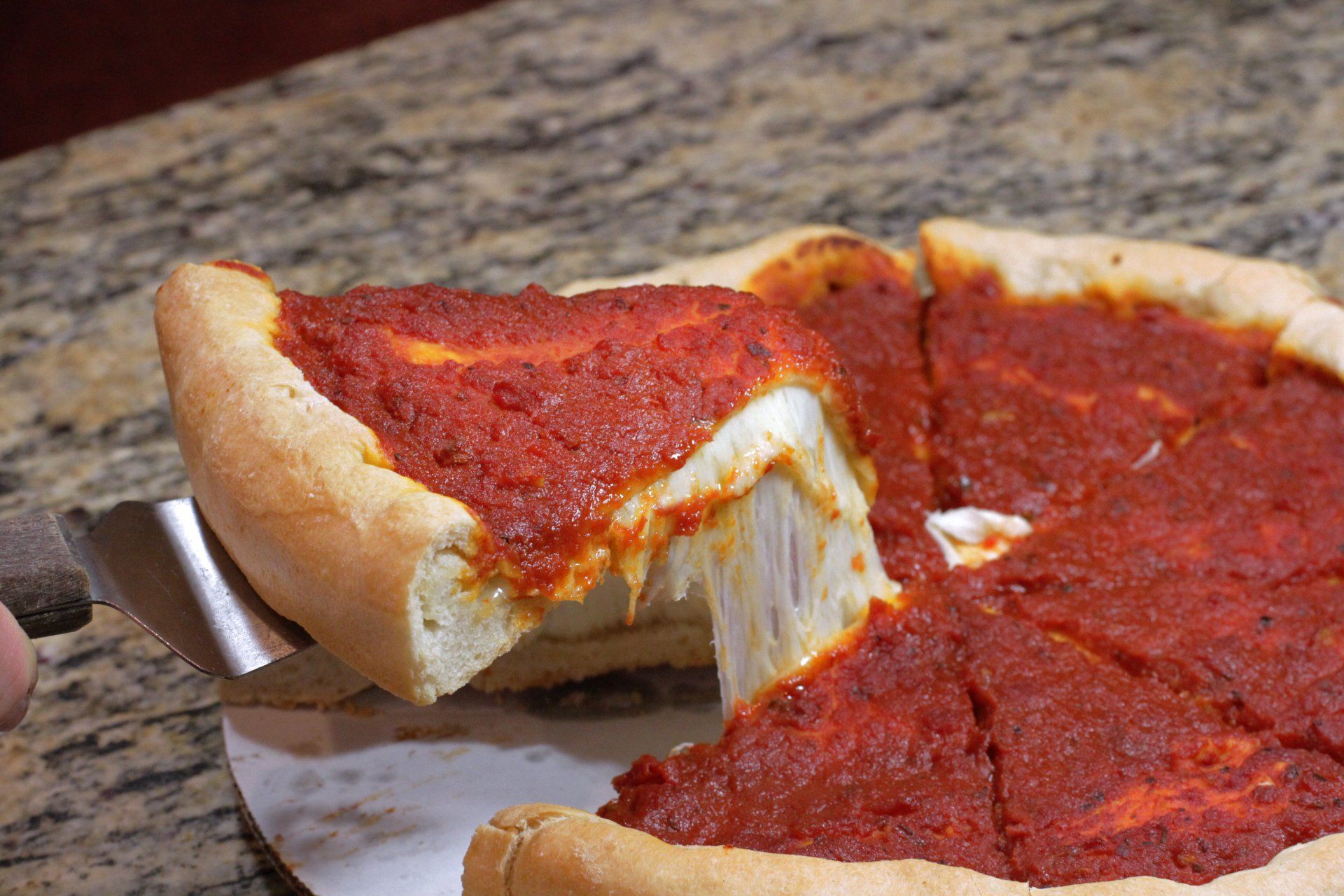 A pizza with a slice taken out of it on a table.
