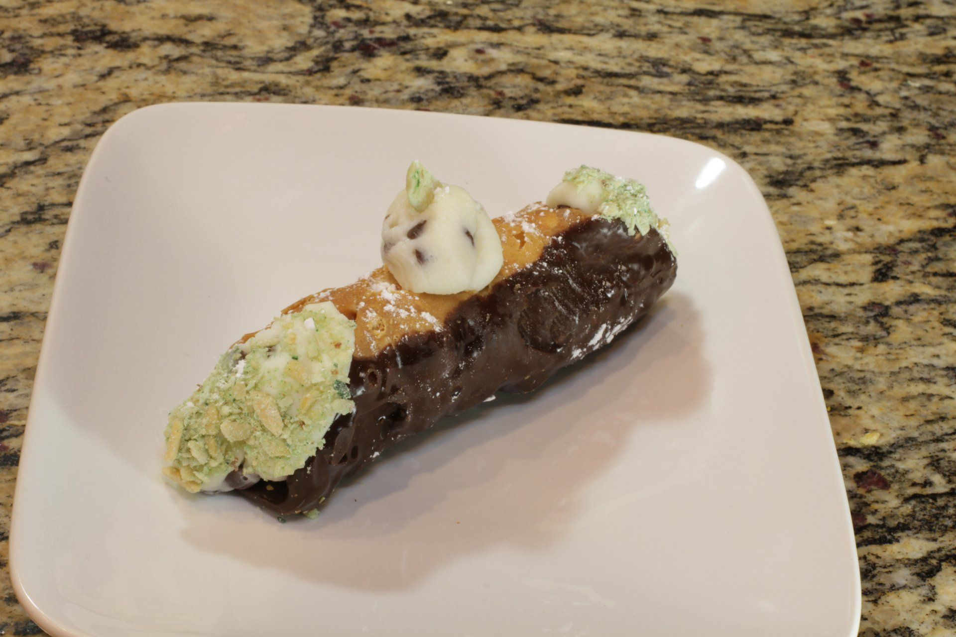 A close up of a dessert on a white plate on a counter.